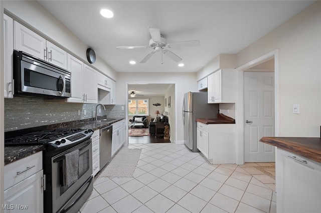 7278 Barton Hill Dr, Parma, OH 44129 - kitchen featuring stainless steel appliances, a ceiling fan, backsplash, a sink, and white cabinetry