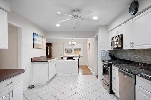 7278 Barton Hill Dr, Parma, OH 44129 - kitchen with appliances with stainless steel finishes, backsplash, a ceiling fan, white cabinetry, and dark countertops