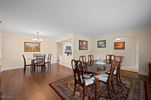 7278 Barton Hill Dr, Parma, OH 44129 - dining area featuring dark wood-type flooring, a chandelier, ornamental molding, and baseboards