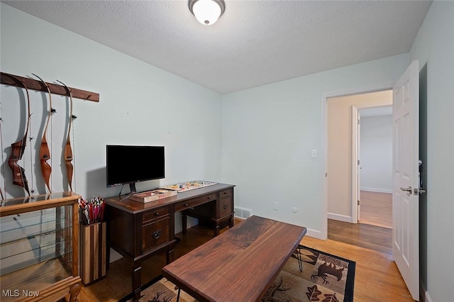 7278 Barton Hill Dr, Parma, OH 44129 - living area with wood finished floors, baseboards, a desk, and a textured ceiling