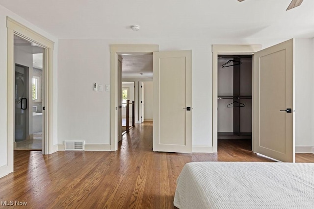 21262 S Woodland Rd, Shaker Heights, OH 44122 - unfurnished bedroom with wood finished floors, a spacious closet, baseboards, and a closet