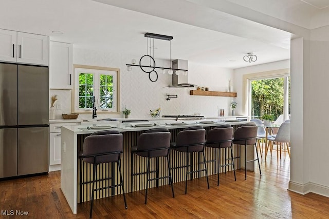 21262 S Woodland Rd, Shaker Heights, OH 44122 - kitchen featuring stainless steel refrigerator, range hood, white cabinets, a sink, and tasteful backsplash