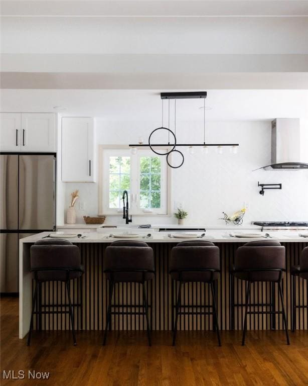 21262 S Woodland Rd, Shaker Heights, OH 44122 - kitchen featuring stainless steel appliances, wall chimney range hood, white cabinetry, a sink, and light countertops
