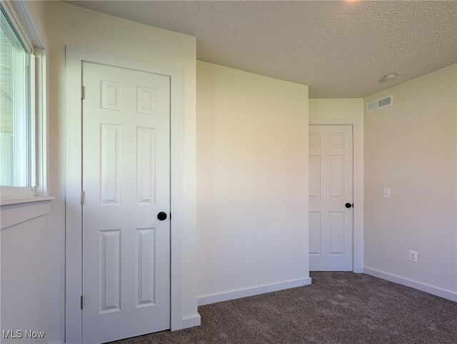 3509 Jerrold Blvd, Brunswick, OH 44212 - unfurnished bedroom with dark carpet, a textured ceiling, and baseboards