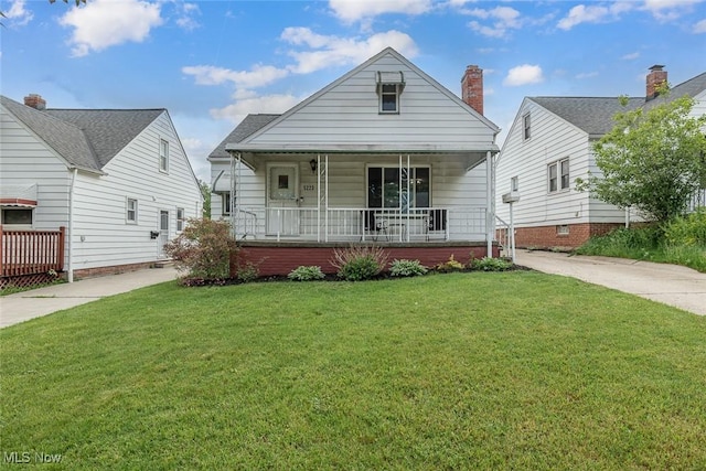 5223 E 115th St, Garfield Heights, OH 44125 - view of front of house featuring covered porch, a front lawn, and a chimney