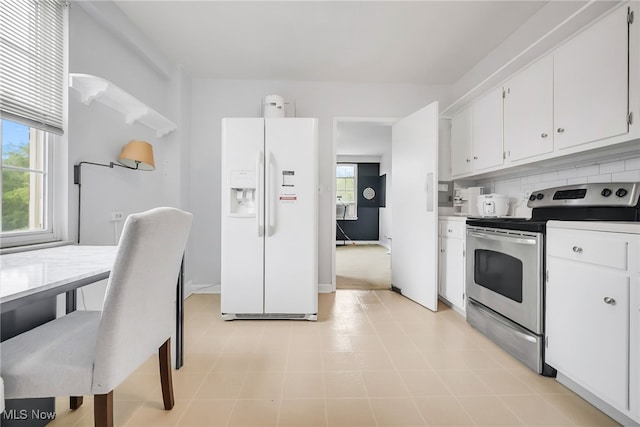 13800 Fairhill Rd Unit 418, Shaker Heights, OH 44120 - kitchen with white fridge with ice dispenser, electric range, white cabinets, decorative backsplash, and plenty of natural light