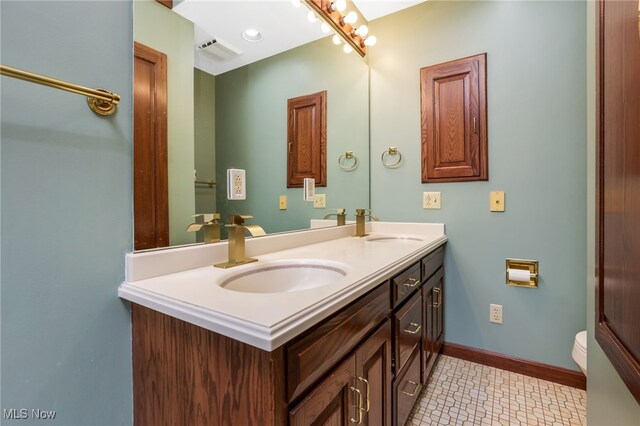 2015 Dunzweiler Dr, Zanesville, OH 43701 - bathroom with double vanity, toilet, and baseboards