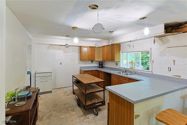 3407 State Route 113 E, Milan, OH 44846 - kitchen featuring a sink, brown cabinets, hanging light fixtures, a peninsula, and light countertops