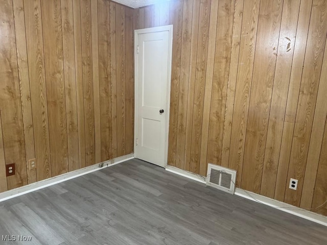 1090 Hartford Ave, Akron, OH 44320 - empty room with wooden walls, wood finished floors, and baseboards