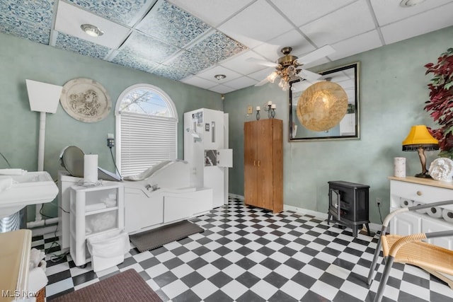 7285 Center St, Mentor, OH 44060 - bedroom with tile patterned floors, a wood stove, a drop ceiling, and baseboards