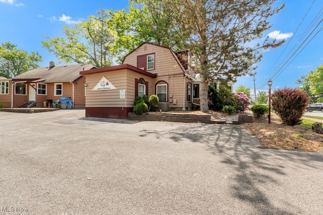 7285 Center St, Mentor, OH 44060 - dutch colonial with a gambrel roof and central AC unit