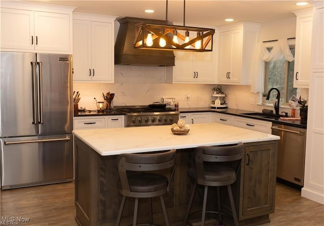 646 Ridgewood Dr, Coshocton, OH 43812 - kitchen with appliances with stainless steel finishes, a sink, custom range hood, a kitchen island, and white cabinets
