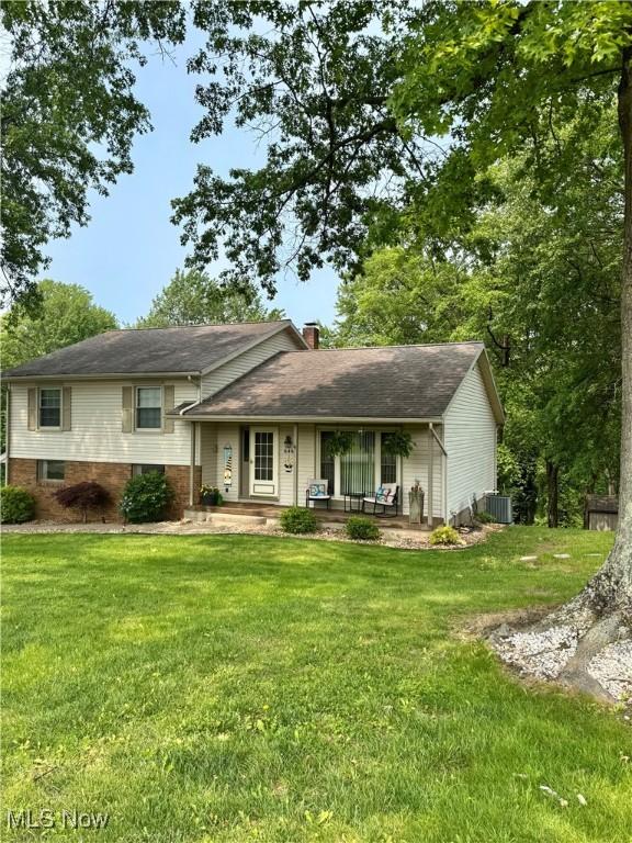 646 Ridgewood Dr, Coshocton, OH 43812 - tri-level home with a front lawn, a chimney, and central air condition unit