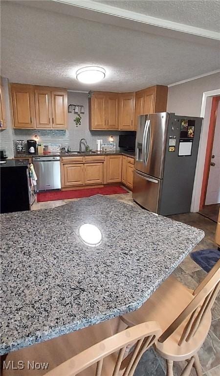 550 E Pleasant Valley Rd, Seven Hills, OH 44131 - kitchen with appliances with stainless steel finishes, a textured ceiling, a sink, and dark stone countertops