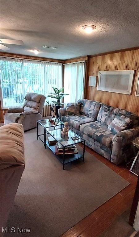 550 E Pleasant Valley Rd, Seven Hills, OH 44131 - living room featuring wood walls, a textured ceiling, wood finished floors, and a ceiling fan