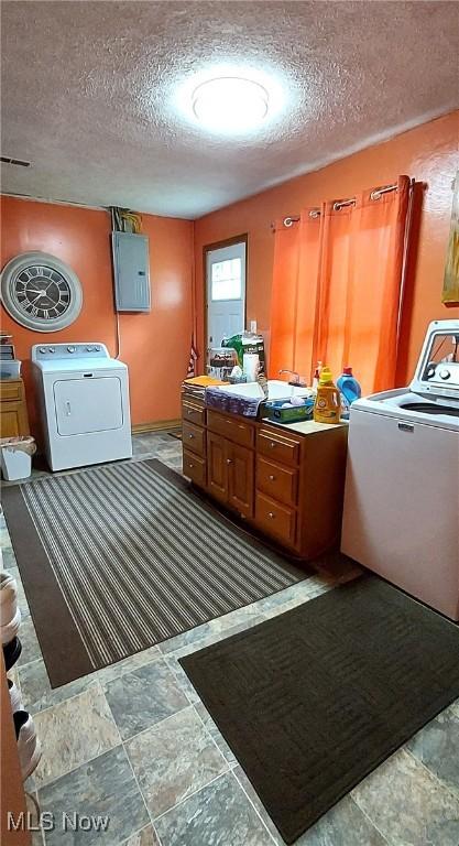 550 E Pleasant Valley Rd, Seven Hills, OH 44131 - laundry area featuring washer / dryer, electric panel, a textured ceiling, and light stone finish flooring