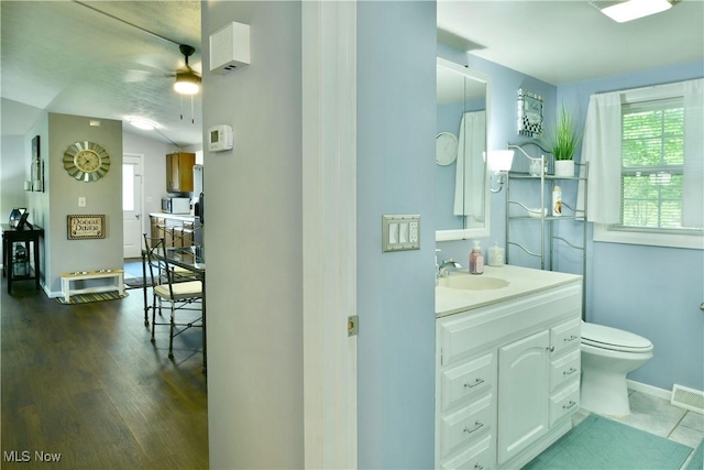 377 Henn Hyde Rd NE, Warren, OH 44484 - bathroom with vanity, toilet, ceiling fan, wood finished floors, and baseboards