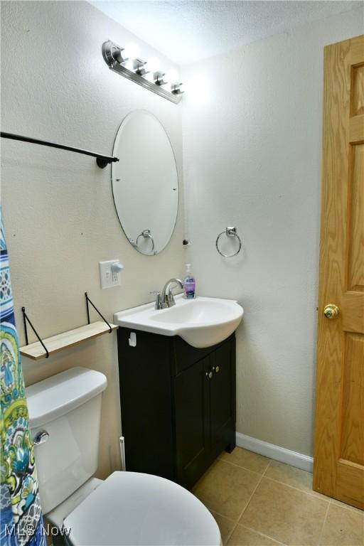 377 Henn Hyde Rd NE, Warren, OH 44484 - full bathroom featuring vanity, tile patterned floors, toilet, and baseboards