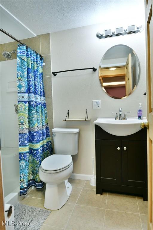 377 Henn Hyde Rd NE, Warren, OH 44484 - full bathroom featuring vanity, toilet, tile patterned floors, a textured ceiling, and baseboards