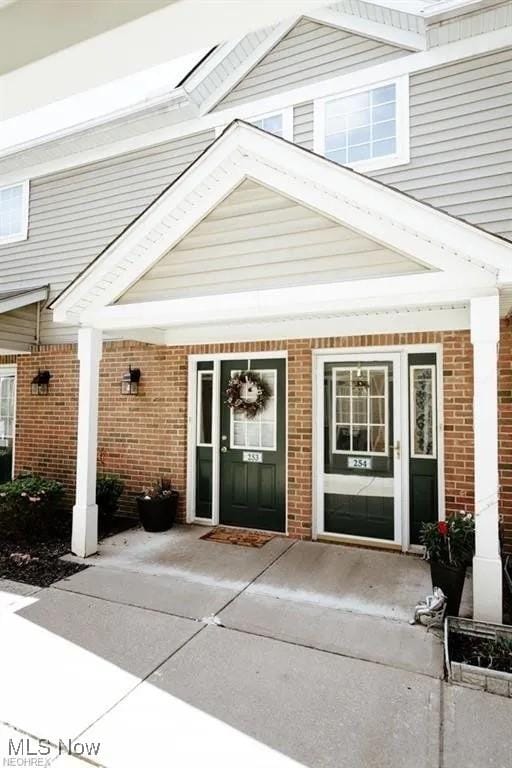 3375 Lenox Village Dr Unit 253, Fairlawn, OH 44333 - view of exterior entry with brick siding and a porch