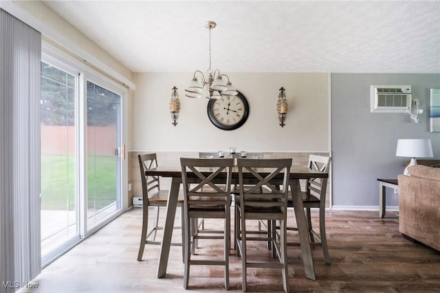 1298 Elberon Ave, Salem, OH 44460 - dining space with a wall mounted air conditioner, wood finished floors, a chandelier, and a textured ceiling