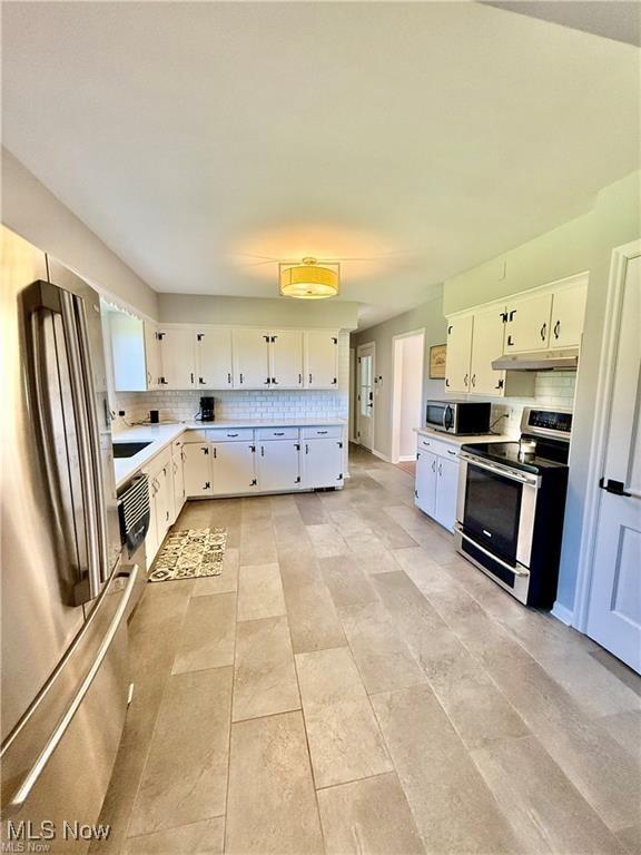 6911 Post Ln, Hudson, OH 44236 - kitchen featuring stainless steel appliances, backsplash, white cabinets, light countertops, and under cabinet range hood