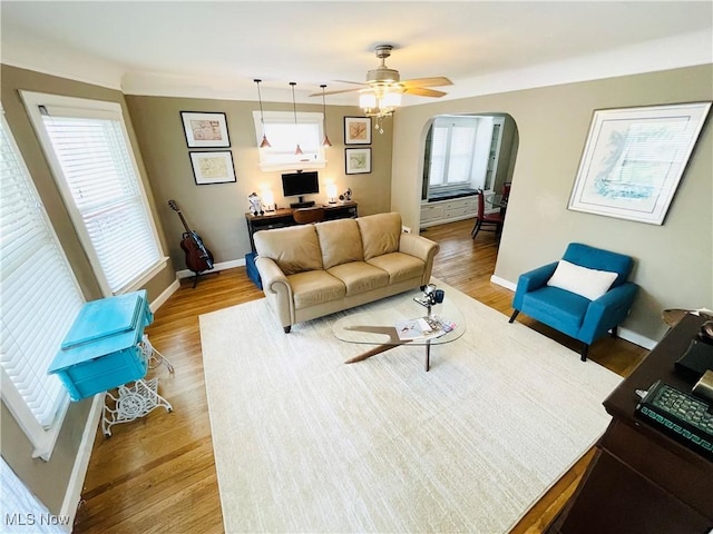 1630 Olivewood Ave, Lakewood, OH 44107 - living area featuring a desk, light wood-type flooring, arched walkways, baseboards, and a ceiling fan