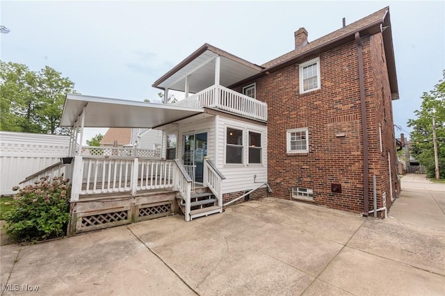 2224 Emily Ave, Lakewood, OH 44107 - back of house featuring a balcony, a chimney, a patio area, brick siding, and a wooden deck