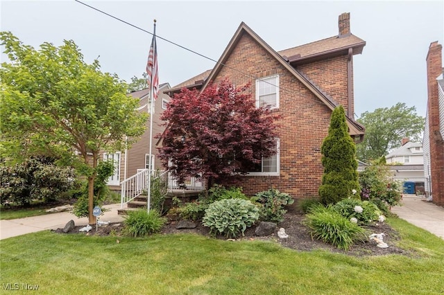 2224 Emily Ave, Lakewood, OH 44107 - view of front of house featuring brick siding, a front lawn, and a chimney