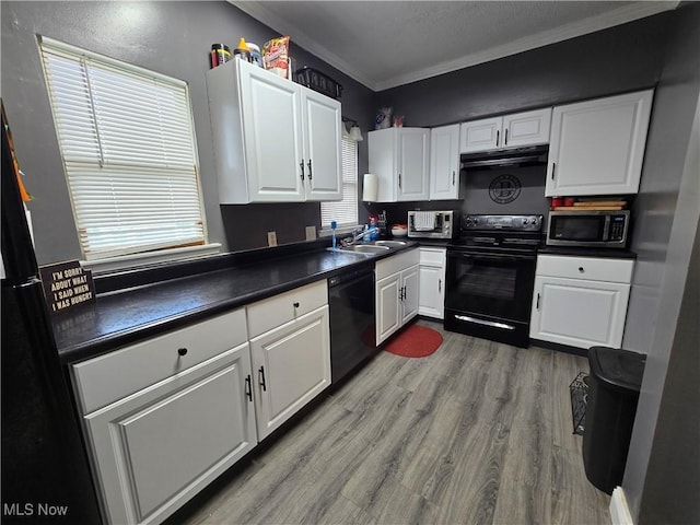 815 Denman Ave, Coshocton, OH 43812 - kitchen with black appliances, under cabinet range hood, dark countertops, crown molding, and white cabinetry