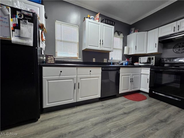 815 Denman Ave, Coshocton, OH 43812 - kitchen with black appliances, ornamental molding, dark countertops, under cabinet range hood, and white cabinets