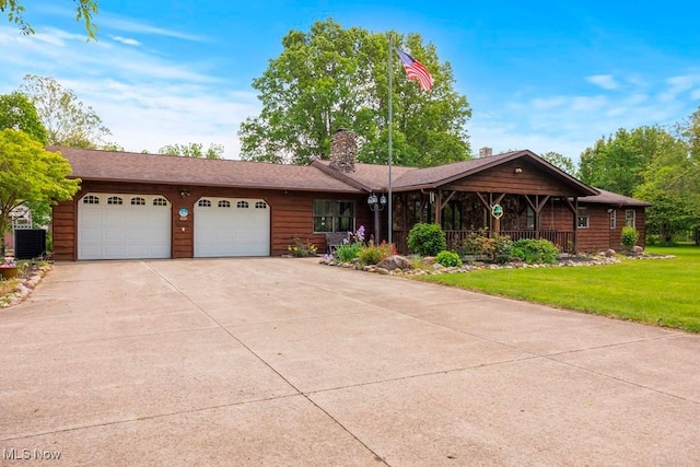 10877 Butternut Ridge Rd, Elyria, OH 44035 - view of front facade with central AC unit, an attached garage, concrete driveway, a front lawn, and a chimney