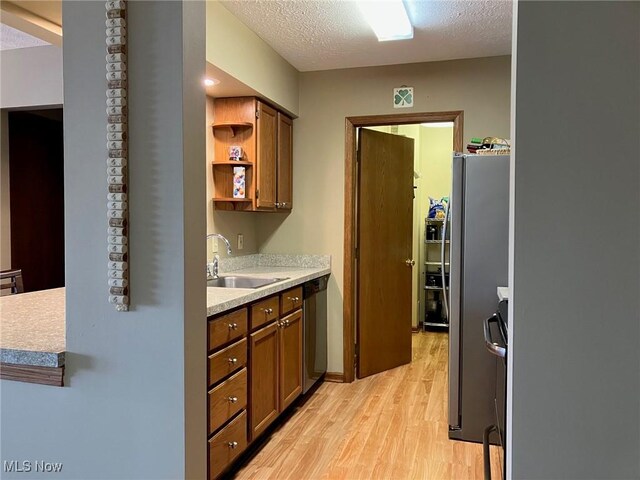 19510 Lorain Rd, Fairview Park, OH 44126 - kitchen with a sink, dishwasher, light wood-style flooring, light countertops, and brown cabinets
