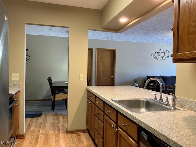 19510 Lorain Rd, Fairview Park, OH 44126 - kitchen featuring a sink, light wood finished floors, dishwashing machine, stainless steel range, and baseboards