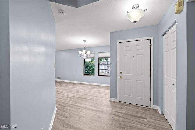 6465 Saint Andrews Dr Unit 6, Canfield, OH 44406 - foyer featuring light wood-style floors, baseboards, and a chandelier