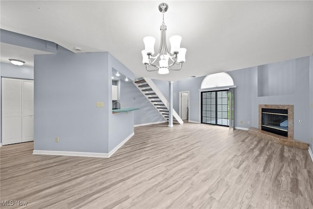 6465 Saint Andrews Dr Unit 6, Canfield, OH 44406 - unfurnished living room with light wood-style floors, a chandelier, and baseboards