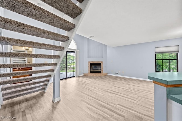 6465 Saint Andrews Dr Unit 6, Canfield, OH 44406 - unfurnished living room featuring baseboards, wood finished floors, and a glass covered fireplace