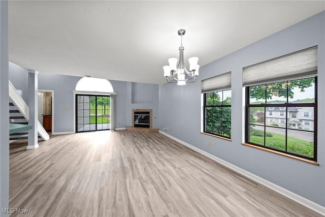 6465 Saint Andrews Dr Unit 6, Canfield, OH 44406 - unfurnished living room featuring plenty of natural light, wood finished floors, stairway, and a chandelier
