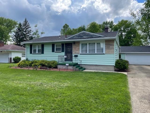1148 Miami Ave, Youngstown, OH 44505 - view of front facade featuring a chimney, a front yard, and a garage