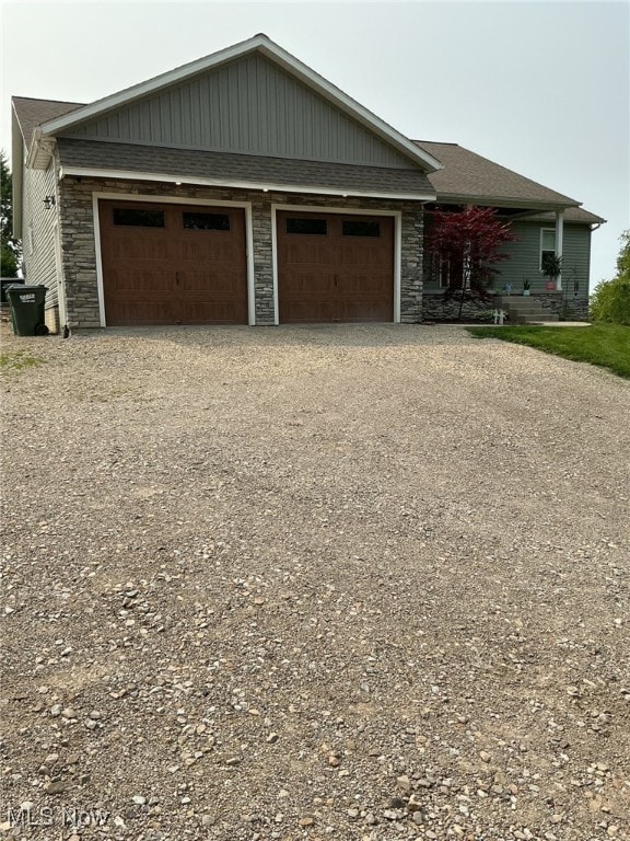 7030 Jones Rd, Nashport, OH 43830 - view of front of house featuring driveway, stone siding, and a garage