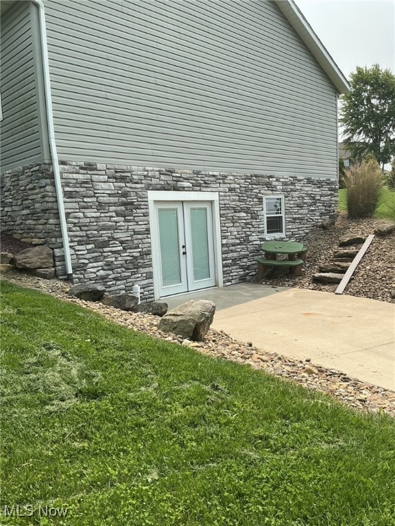 7030 Jones Rd, Nashport, OH 43830 - doorway to property with stone siding, french doors, a patio area, and a yard