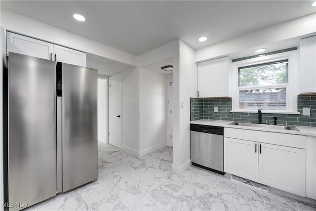2330 Traymore Rd, University Heights, OH 44118 - kitchen featuring stainless steel appliances, a sink, baseboards, light countertops, and white cabinetry