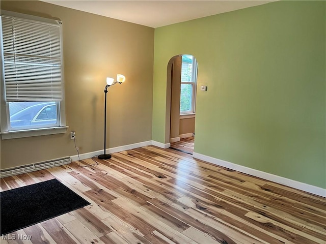 1705 Etruria St, East Liverpool, OH 43920 - unfurnished room with arched walkways, baseboards, and wood finished floors