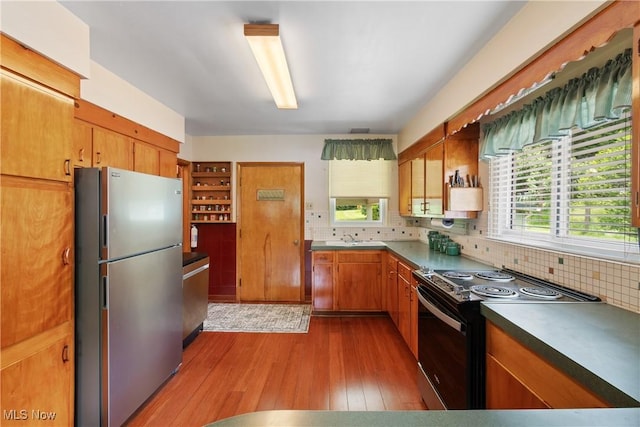 4937 Stevens Rd, Akron, OH 44319 - kitchen featuring stainless steel appliances, hardwood / wood-style floors, decorative backsplash, brown cabinetry, and dark countertops