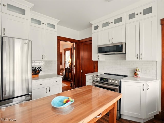 126 W Jefferson St, Jefferson, OH 44047 - kitchen featuring appliances with stainless steel finishes, light countertops, tasteful backsplash, white cabinetry, and glass insert cabinets