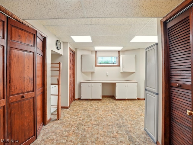 126 W Jefferson St, Jefferson, OH 44047 - kitchen featuring a paneled ceiling, baseboards, white cabinets, and light countertops