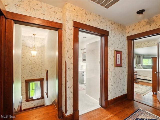 126 W Jefferson St, Jefferson, OH 44047 - corridor with hardwood / wood-style floors, healthy amount of natural light, wallpapered walls, and baseboards
