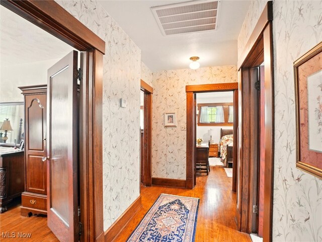 126 W Jefferson St, Jefferson, OH 44047 - hallway with light wood-style floors and wallpapered walls
