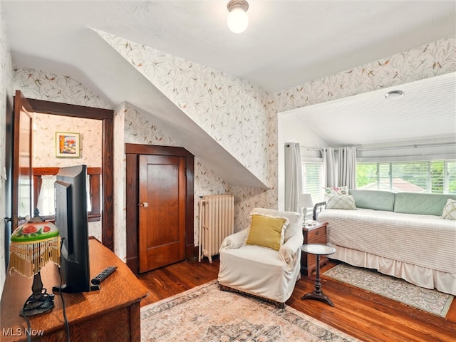 126 W Jefferson St, Jefferson, OH 44047 - bedroom with radiator heating unit, wood finished floors, vaulted ceiling, and wallpapered walls