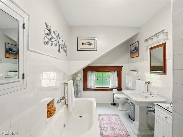 126 W Jefferson St, Jefferson, OH 44047 - bathroom featuring tile walls, toilet, a tub to relax in, tile patterned floors, and a wainscoted wall
